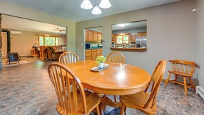 A dining area with a round wooden table, six chairs, and a chandelier. - Wooded Applegate Retreat w/ Private Trail Access (Applegate)