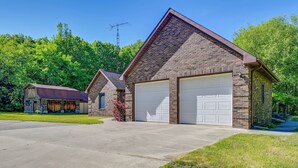 A two-story brick house with a garage, a covered porch, and a satellite dish. - Wooded Applegate Retreat w/ Private Trail Access (Applegate)
