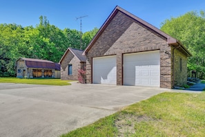 A two-story brick house with a garage, a covered porch, and a satellite dish.