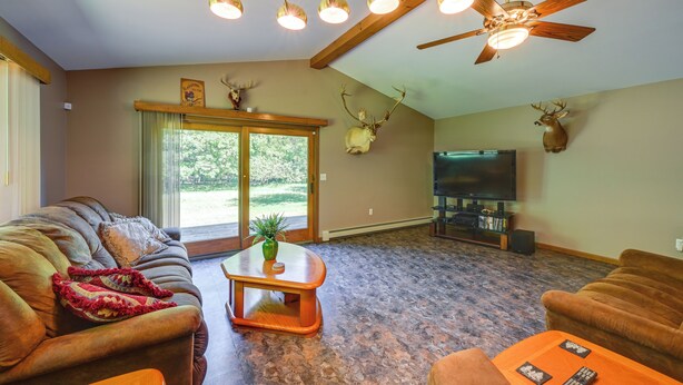 A living room with a sofa, coffee table, and television. - Wooded Applegate Retreat w/ Private Trail Access (Applegate)