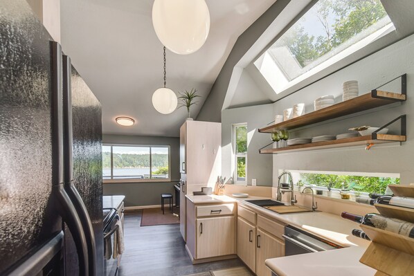 Eine moderne Küche mit großem Fenster, Einbauschränken und einem Kühlschrank.