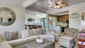 A living room with a sectional sofa, a chaise lounge, a coffee table, and a wicker ottoman. - Red, White & Beach! 5BR Atlantic Beach Cottage (Atlantic Beach)