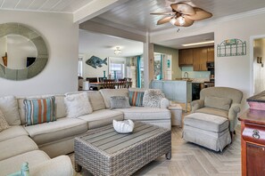 A living room with a sectional sofa, a chaise lounge, a coffee table, and a wicker ottoman. - Red, White & Beach! 5BR Atlantic Beach Cottage (Atlantic Beach)