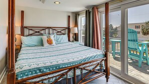 A room with a bed, a window, and a view of outdoor chairs. - Red, White & Beach! 5BR Atlantic Beach Cottage (Atlantic Beach)