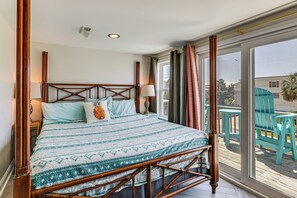 A room with a bed, a window, and a view of outdoor chairs. - Red, White & Beach! 5BR Atlantic Beach Cottage (Atlantic Beach)