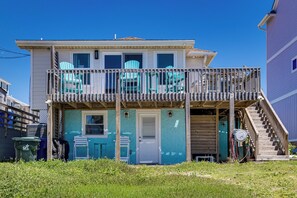 A two-story house with a balcony, a door, and a staircase leading to the upper level. - Red, White & Beach! 5BR Atlantic Beach Cottage (Atlantic Beach)