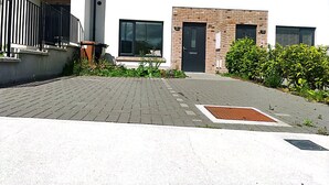 A modern building with a brick entrance, large windows, and a paved driveway. - Spacious Double Room with Garden & Parking – Suitable for male or Couple (Wicklow)