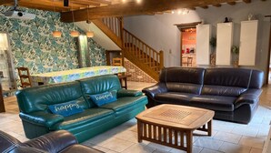 A living room with a green sofa, a black sofa, and a wooden coffee table. - Large family home in Normandy (Ganzeville)
