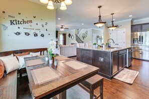 Eine moderne Küche mit Essbereich, Holzmöbeln und Wanddekoration.