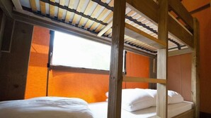 A bunk bed room with a window, wooden beams, and orange walls. - Holiday Home in Noord-scharwoude With Wi-fi (Noord-Scharwoude)