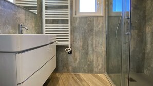 A modern bathroom with a shower, a built-in sink, and a towel rack. - Holiday Home in Dordrecht With Terrace (Dordrecht)