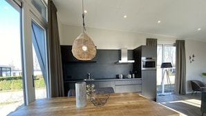 A modern kitchen with a dining area, large windows, and a view of the outdoors. - Holiday Home in Dordrecht With Terrace (Dordrecht)