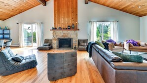 A spacious living area with a stone fireplace, wooden ceiling, and large windows. - 3 Acres, Mtn Views, Hot Tub, Steps to Winery (Richmond)