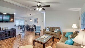 A living room with a sofa, coffee table, and a TV mounted on the wall. - Newly Remodeled, Great Porches, and Dog Friendly (Port O'Connor)