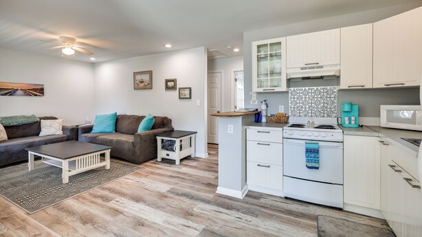 A modern kitchen with white cabinets, a stove, and a microwave. - Steps to Ocean! Family-Friendly Carolina Beach Gem (Carolina Beach)