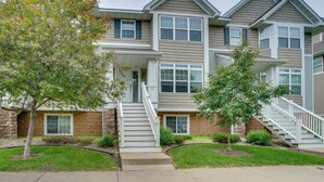 A multi-story residential building with a central staircase, a front porch, and a well-maintained lawn. - Spacious & Quiet Townhome In the Twin Cities (Roseville)