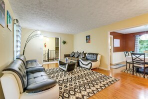 Ein Wohnzimmer mit einer Eckcouch, einem Couchtisch und einem Essbereich mit Tisch und Stühlen.