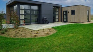 A modern two-story building with large windows, a flat roof, and a small adjacent structure. - Holiday Home in Olburgen With Terrace (Olburgen)