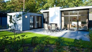 A modern house with a patio, a small garden, and a large glass door leading to an interior space. - Holiday Home in Olburgen With Terrace (Olburgen)