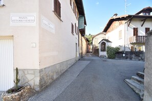 En smal gata med byggnader på båda sidor, och skyltar som visar vägen till ”PIAZZA VITTORIO VENETO” och ”VIA LUIGI CARONES”.