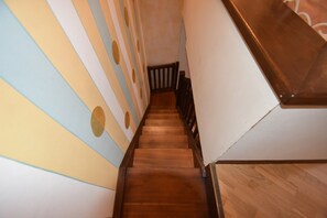 Eine Holztreppe mit gestreifter Wandgestaltung.