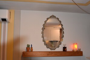 A bathroom with a mirror, a wooden shelf with a cactus, a candle, and a salt lamp. - Apartment in village of Viggiona, Lake Maggiore (Trarego)