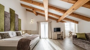 Un dormitorio con cama, escritorio, televisor y sofá.
