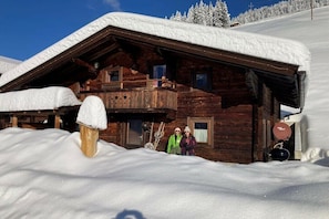 A wooden cabin with a balcony, surrounded by snow. - Holiday apartment Vogelnest (Hippach)
