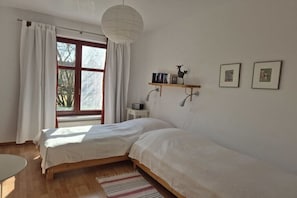 A bedroom with a bed, a window with curtains, a shelf with books and a figurine, and a wall-mounted lamp. - Holiday home in Stolpe with swimming pool (Stolpe)