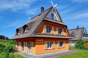 A traditional house with a steeply pitched roof, a chimney, and a sign that reads 'Haus Sonneneck.' - Holiday apartment in Glowe with swimming pool (Glowe)