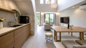 Een moderne keuken met een ingebouwde televisie, een eethoek met een houten tafel en uitzicht op de omgeving.