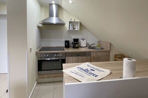 Eine moderne Küche mit Herd, Backofen, Spüle und Kaffeemaschine.