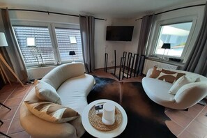 A living room with two sofas, a TV, and a fireplace. - homestead No. 10 - Lina - (Mansfeld)