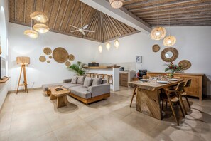 A modern living space with a sofa, dining table, and ceiling fan. - 1BR Romantic Getaway in Ubud, Villa Lojo with Private Pool (Gianyar)
