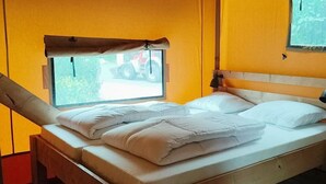 A bed with white bedding, a wooden headboard, and a window with a curtain. - Holiday Home in Noord-scharwoude With Wi-fi (Noord-Scharwoude)