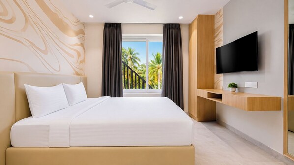 A modern hotel room with a large bed, a flat-screen TV, a balcony with a view of palm trees, and a ceiling fan.