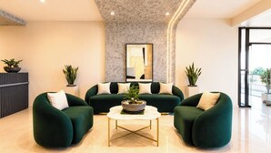 Een moderne woonkamer met een zithoek, een salontafel en decoratieve planten.