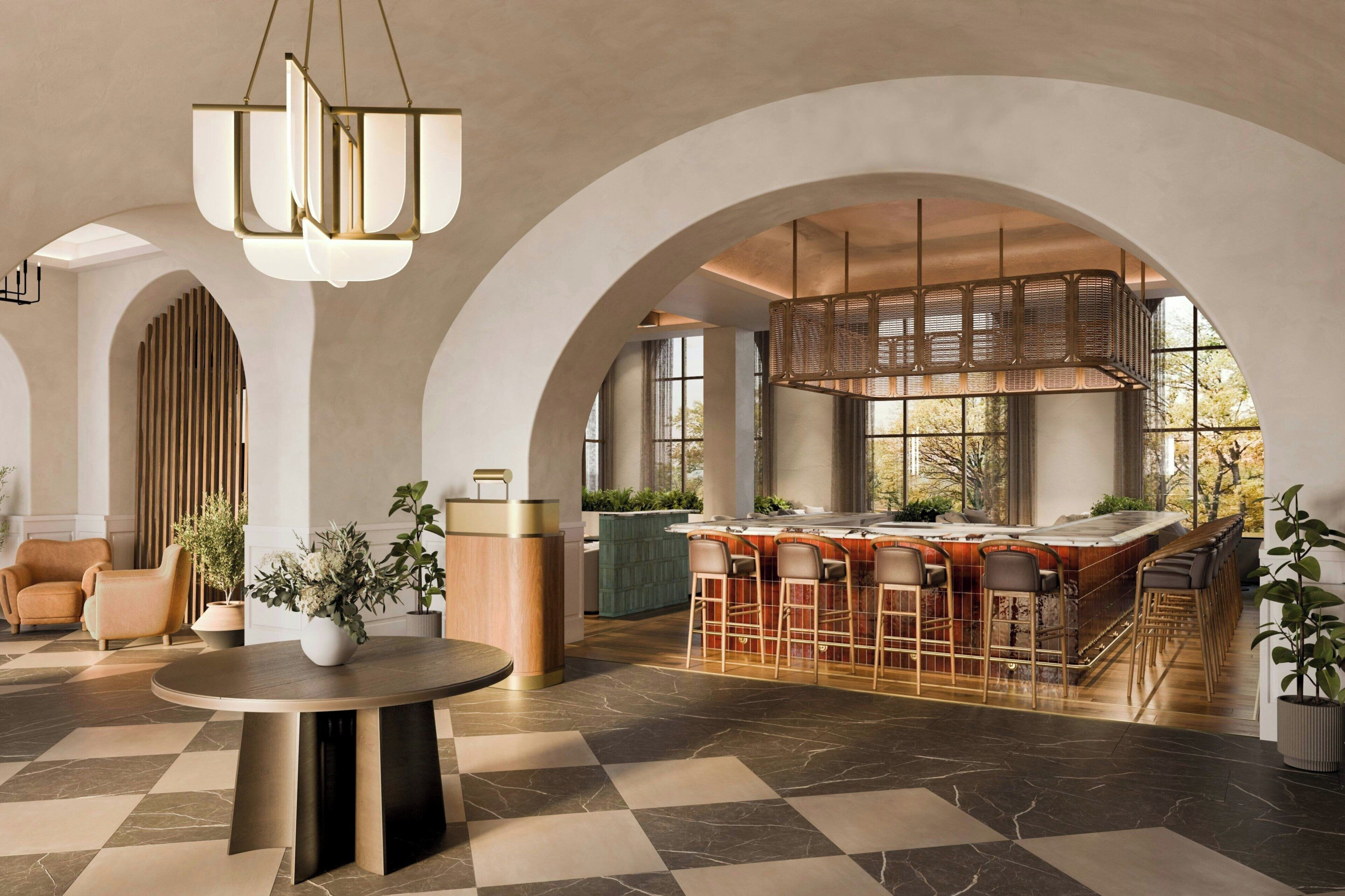 A spacious lobby with a bar area, arched ceilings, and a checkered floor.
