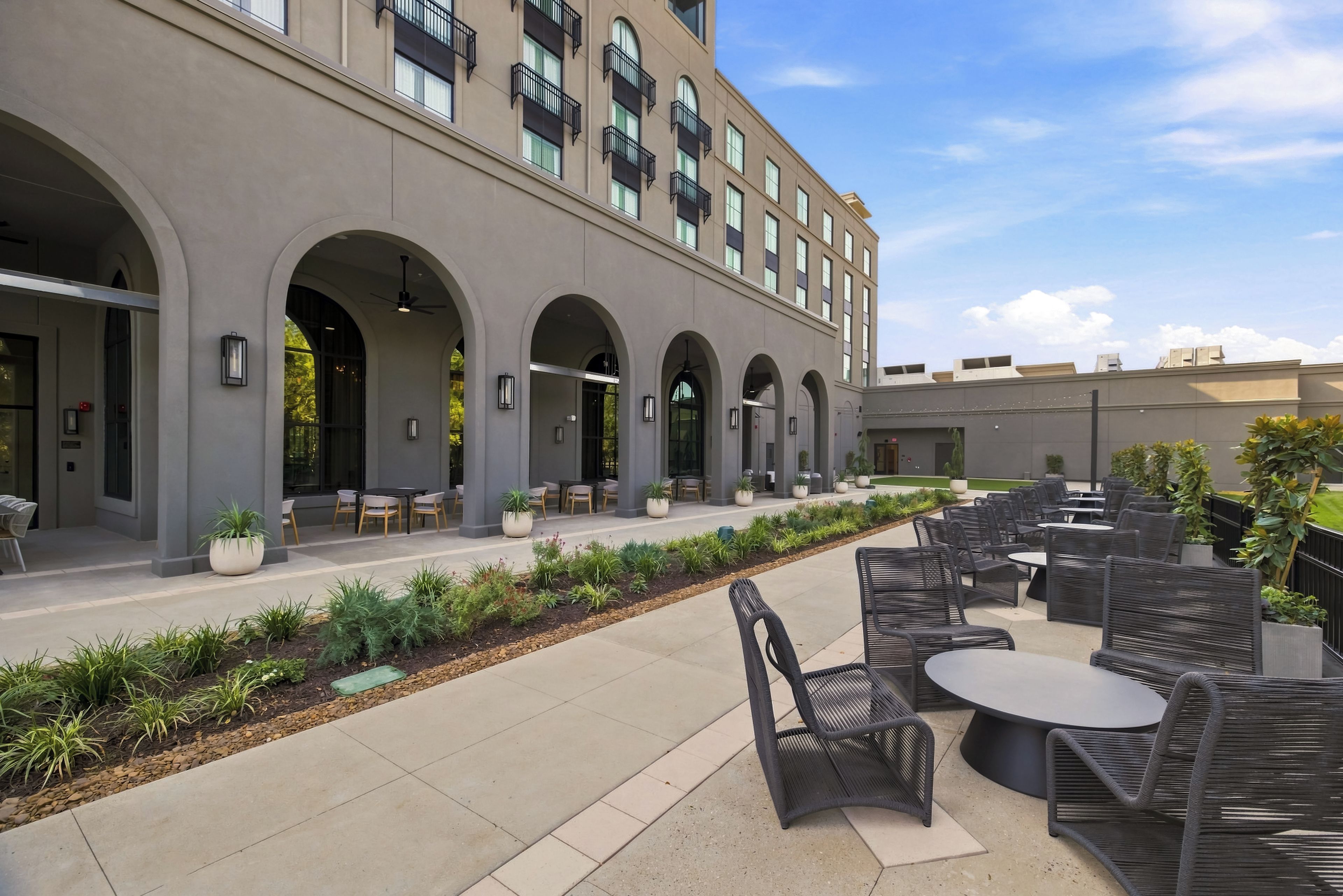 A modern building with outdoor seating and a landscaped garden area.