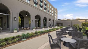 A modern building with outdoor seating and a landscaped garden area.