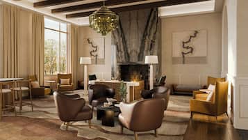 A modern living room with leather sofas, a fireplace, and a chandelier.