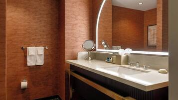 A modern bathroom with two sinks, a large mirror, and a towel rack.