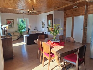 Un espace de vie avec un plancher en bois, comprenant une table à manger, des chaises et un canapé.