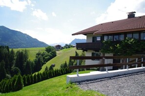 A house with a balcony, surrounded by a green landscape and mountains. - Holiday home with 4 bedrooms (Brandenberg)