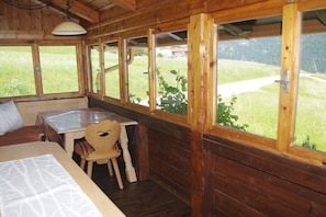 A wooden cabin room with a bed, a table, and a chair. - Holiday home with 4 bedrooms (Brandenberg)