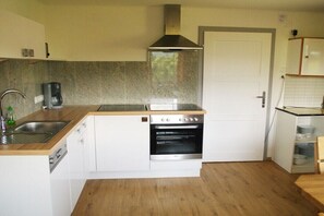 A compact kitchen with a built-in oven, a coffee maker, and a sink. - Holiday home with 4 bedrooms (Brandenberg)