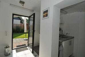 Eine moderne Küche mit weißen Schränken, einer Spüle und einer Tür zum Patio.