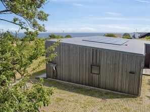 A modern building with a flat roof, a small window, and a solar panel. - 4 Star Holiday Home in Allinge (Allinge)