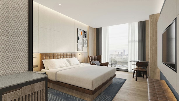 A modern bedroom with a large bed, a desk, a chair, a TV, and a city view. - Four Points by Sheraton Shenzhen Nanshan (Shenzhen)