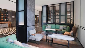 A modern interior with a green sofa, a houndstooth chair, and a small round table.